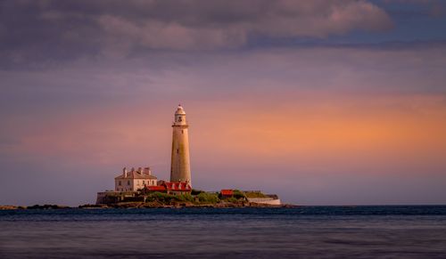 Free Picturesque view of St Mary's Lighthouse at sunset with a dramatic sky. Stock Photo