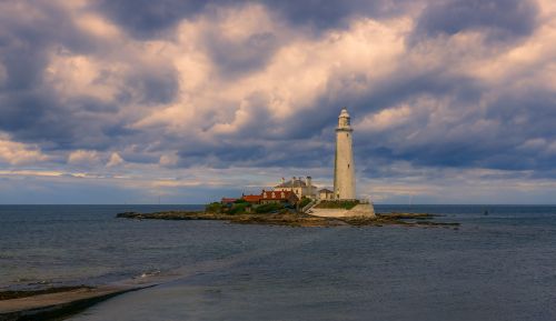 Free Captivating view of St Mary's Lighthouse with dramatic clouds on the coast of England. Stock Photo