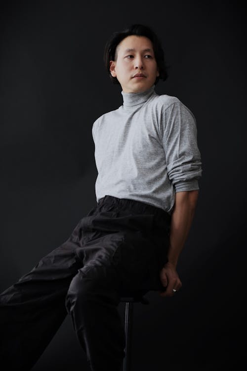 A man in a grey turtleneck and black pants