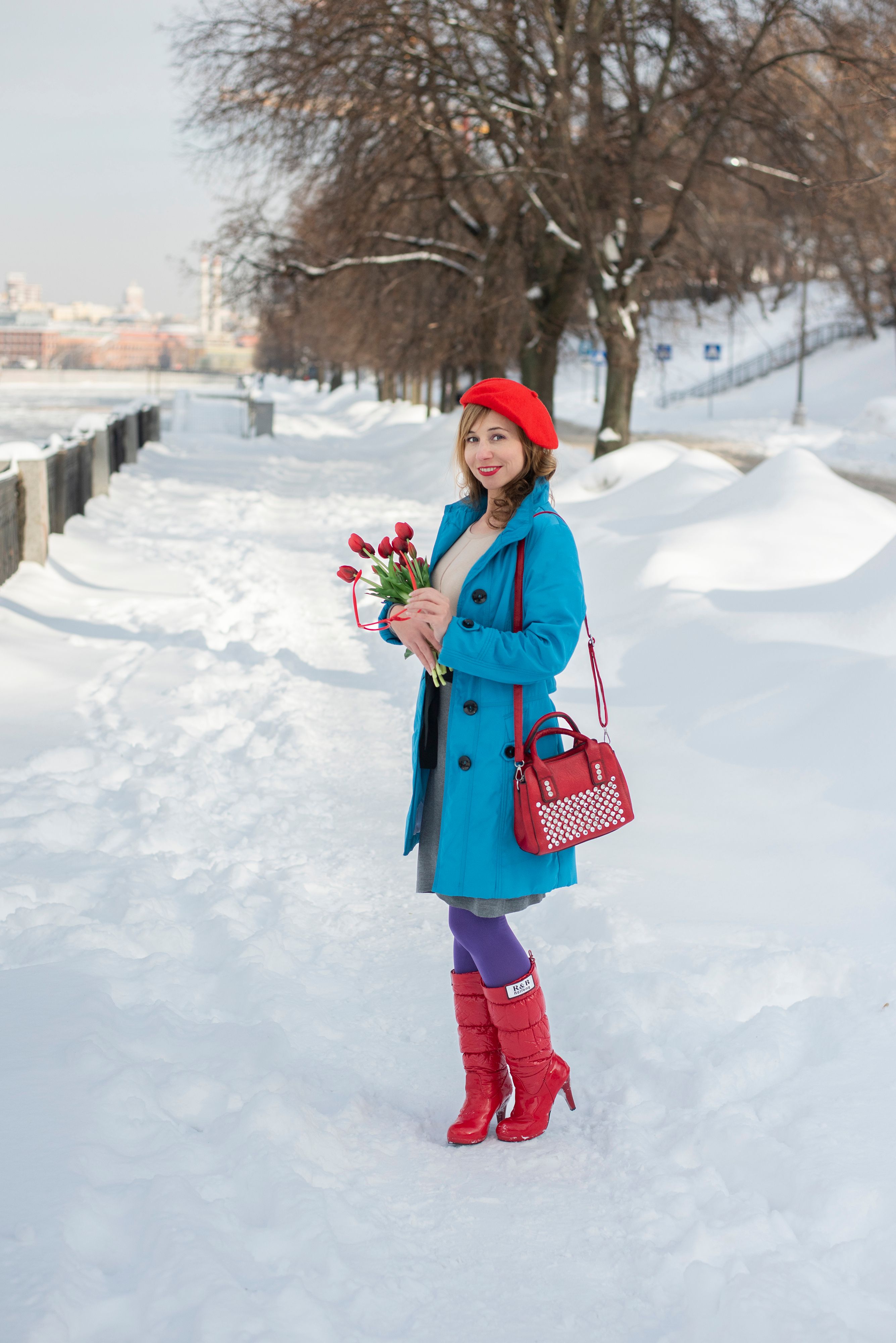 A woman in red boots and a blue coat holding flowers · Free Stock Photo