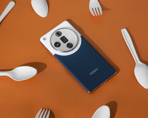 A camera with a lens and a fork on a table