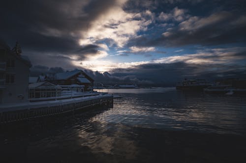 A snowy scene with a dock and buildings