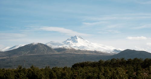 A mountain with snow capped peaks in the distance