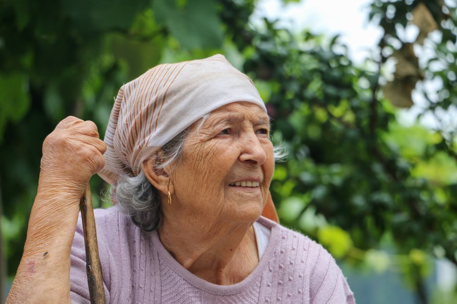 Fotomural Mujer anciana con pañuelo sonriendo al aire libre en Barcelos, Portugal.