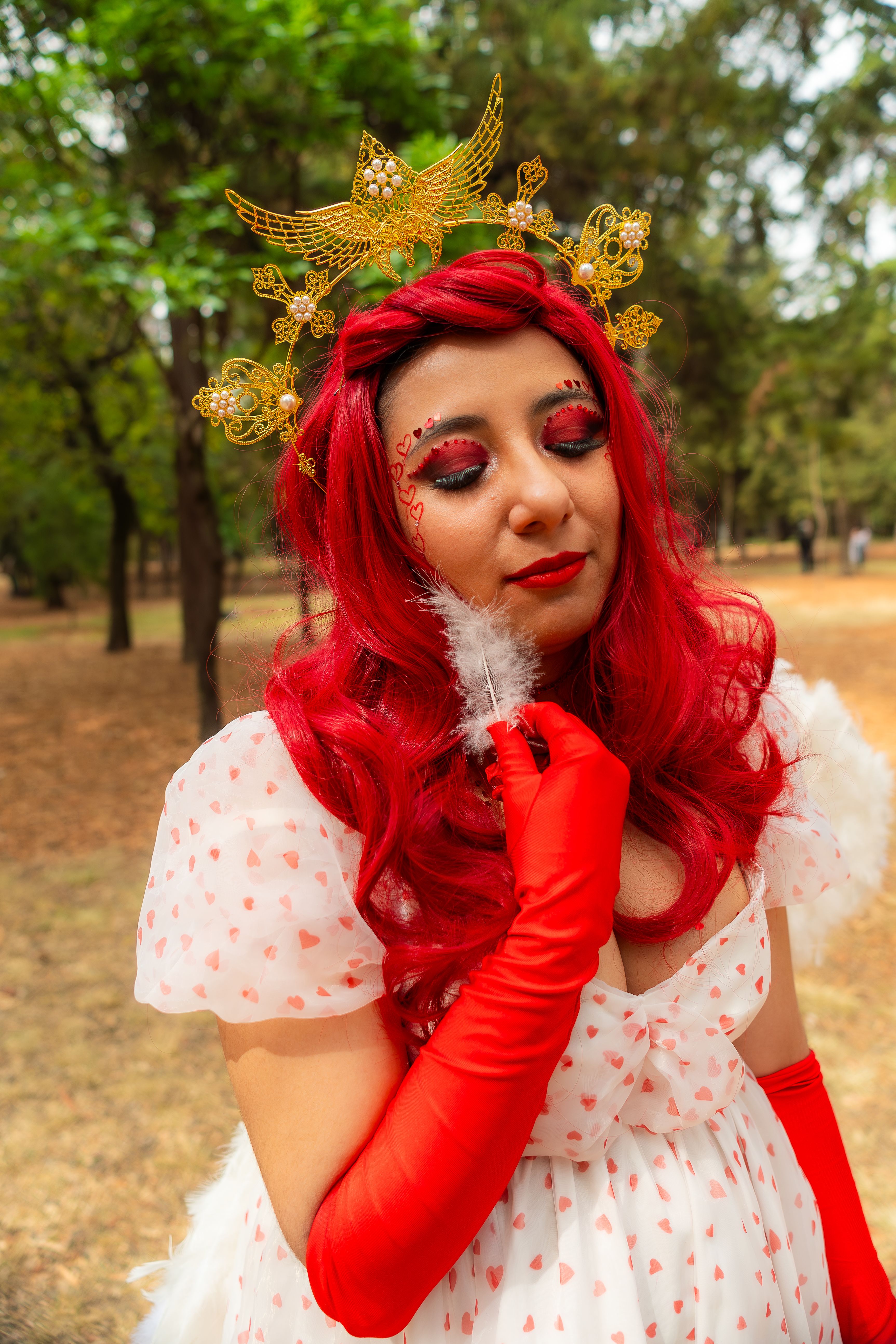 A colorful portrait of a woman in angelic costume with red hair and wings, set outdoors in Ciudad de México.