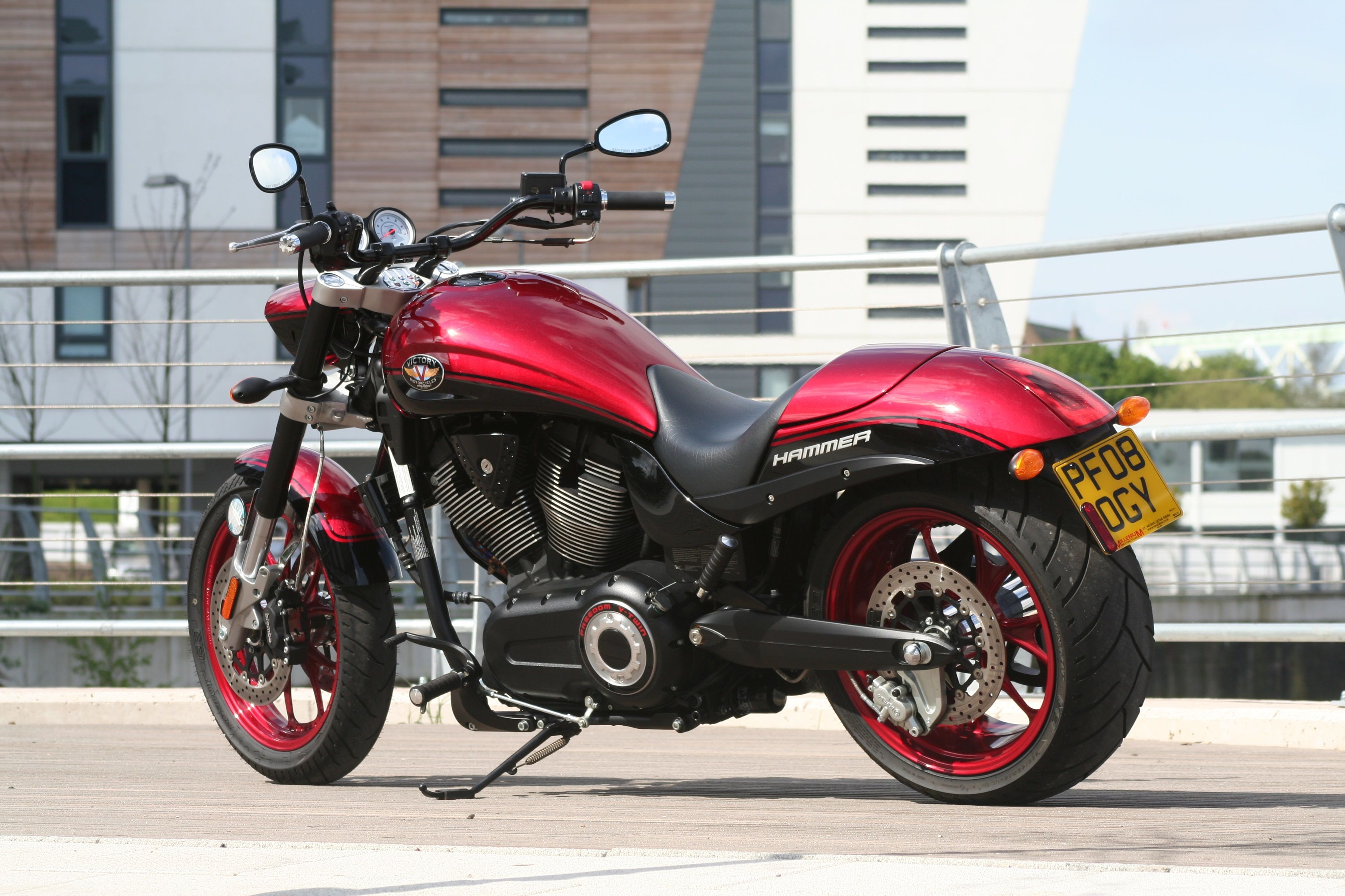 A striking red motorcycle parked in an urban area with modern architecture in Runcorn, England.
