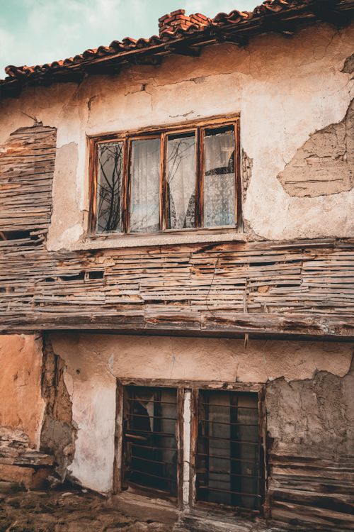 Free A decaying house with broken windows and peeling paint, showing its age and neglect. Stock Photo