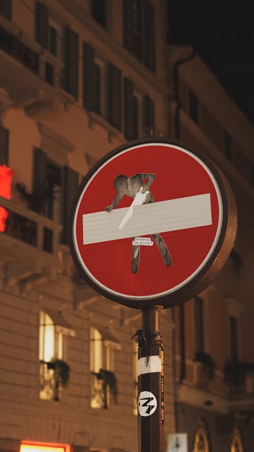 A no dogs sign on a street at night