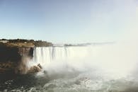 在日光下，尼亚加拉大瀑布的景观令人惊叹，船只和薄雾的氛围被完美捕捉