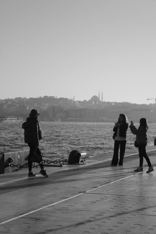 Free Silhouetted figures by the shore with Istanbul skyline in the background. Stock Photo