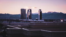 黄昏时分，摩天大楼与远处的山脉映衬着城市天际线，构成了一幅宁静的城市景观