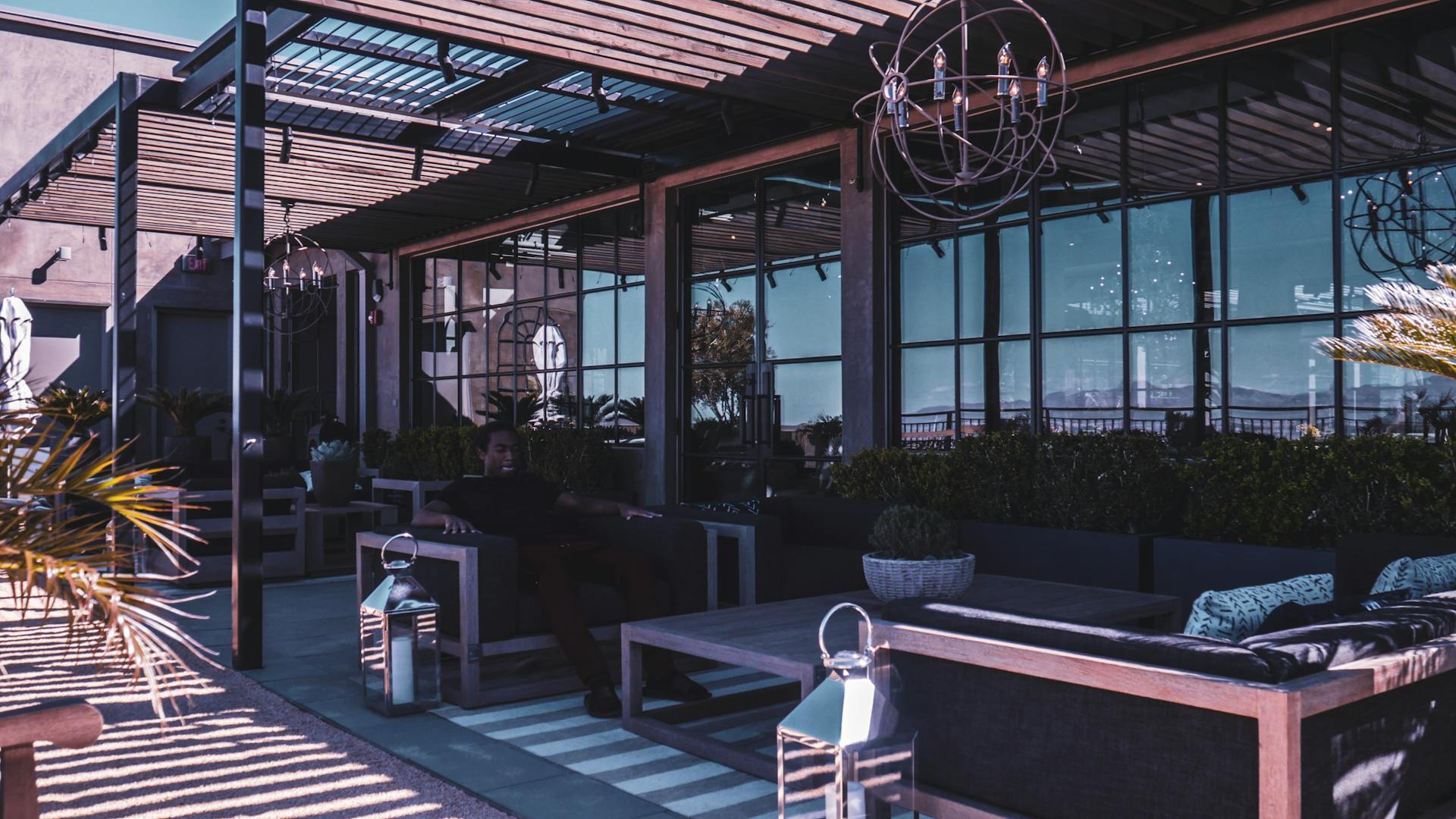 A stylish modern rooftop patio showcasing sleek furniture and elegant lighting at dusk.