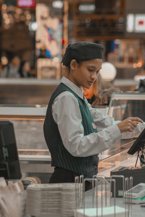 A woman in a uniform is standing at a counter