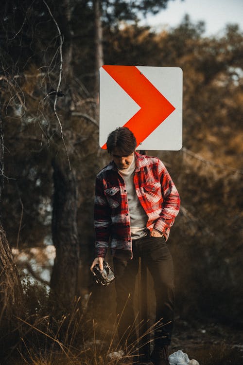 Základová fotografie zdarma na téma červená bunda, dívání se dolů, dopravní značka