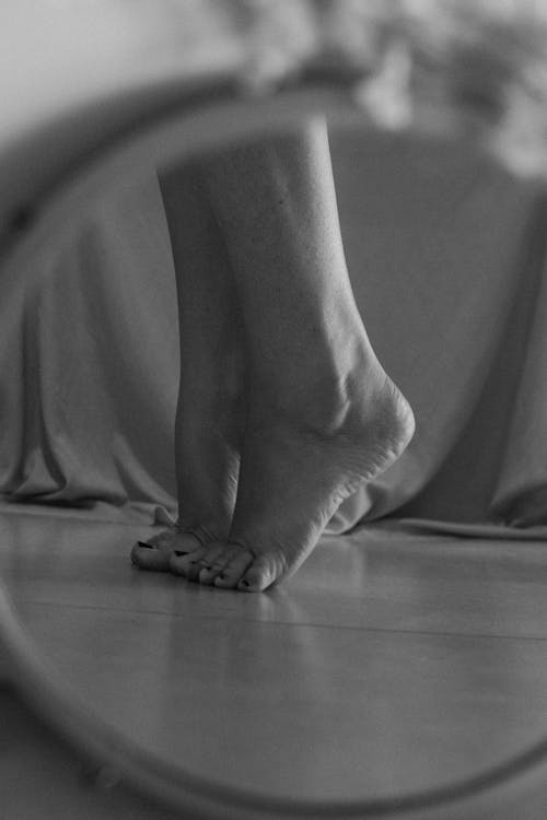 A woman's feet are reflected in a mirror