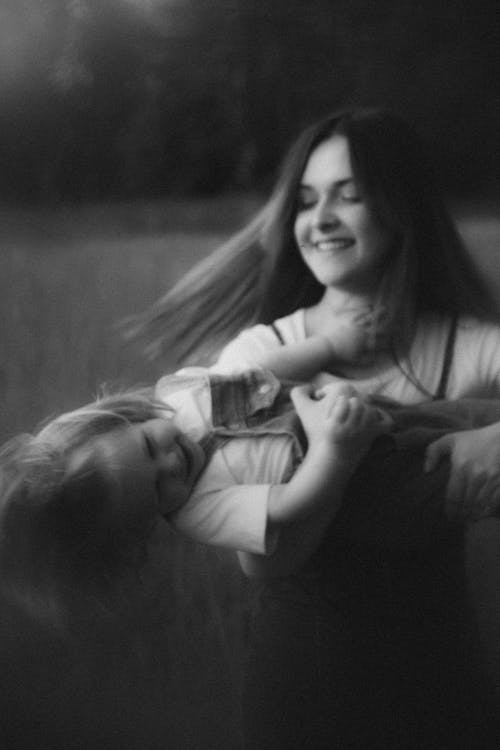 A woman holding a child in a field