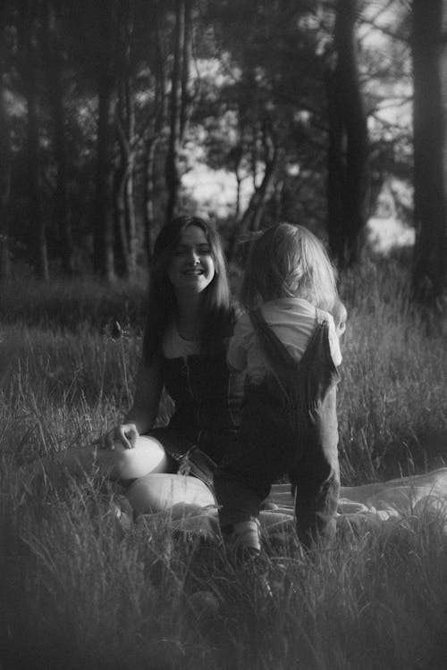 A woman and child sitting in the grass