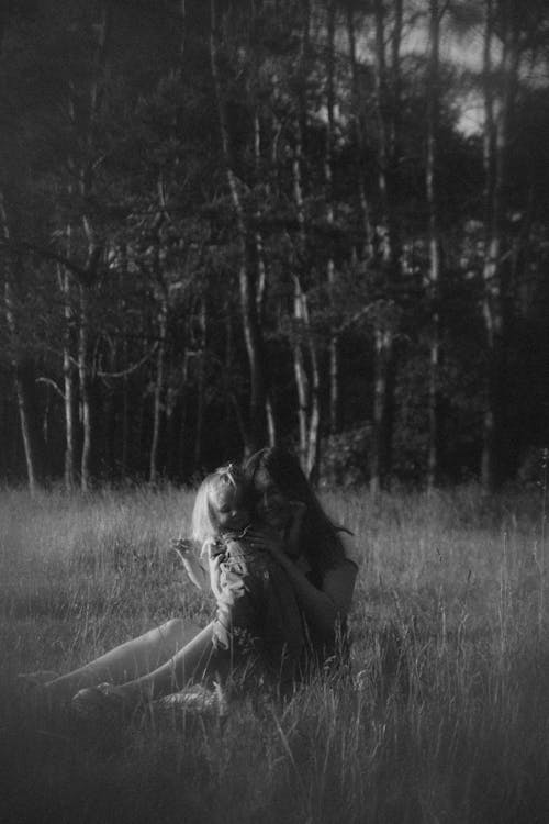 A black and white photo of two people in the grass