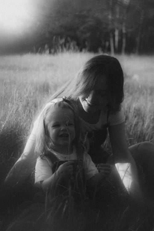 A woman and child sitting in a field