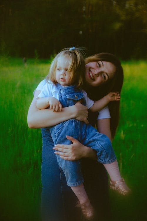 A woman holding a child in a field