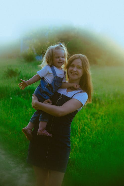 A woman holding a child in a field