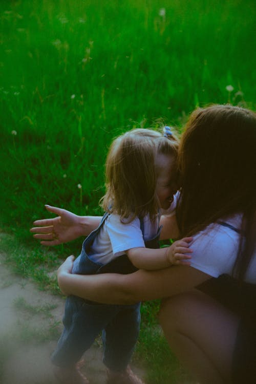 A woman and child hugging in a field