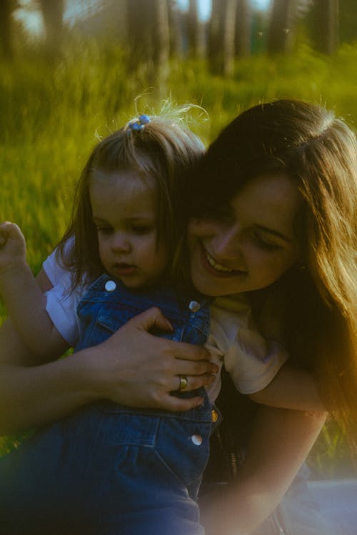 A woman holding a child in the grass