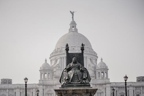 A statue of a king in front of a large building