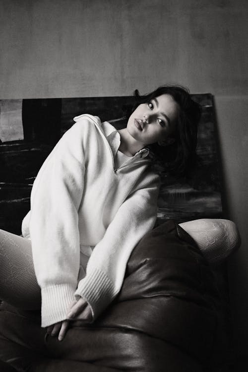 A woman in a white sweater sitting on a couch