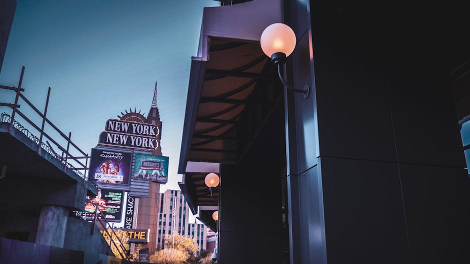 Captivating shot of the New York-New York sign in Las Vegas at twilight, featuring glowing lights and urban architecture.