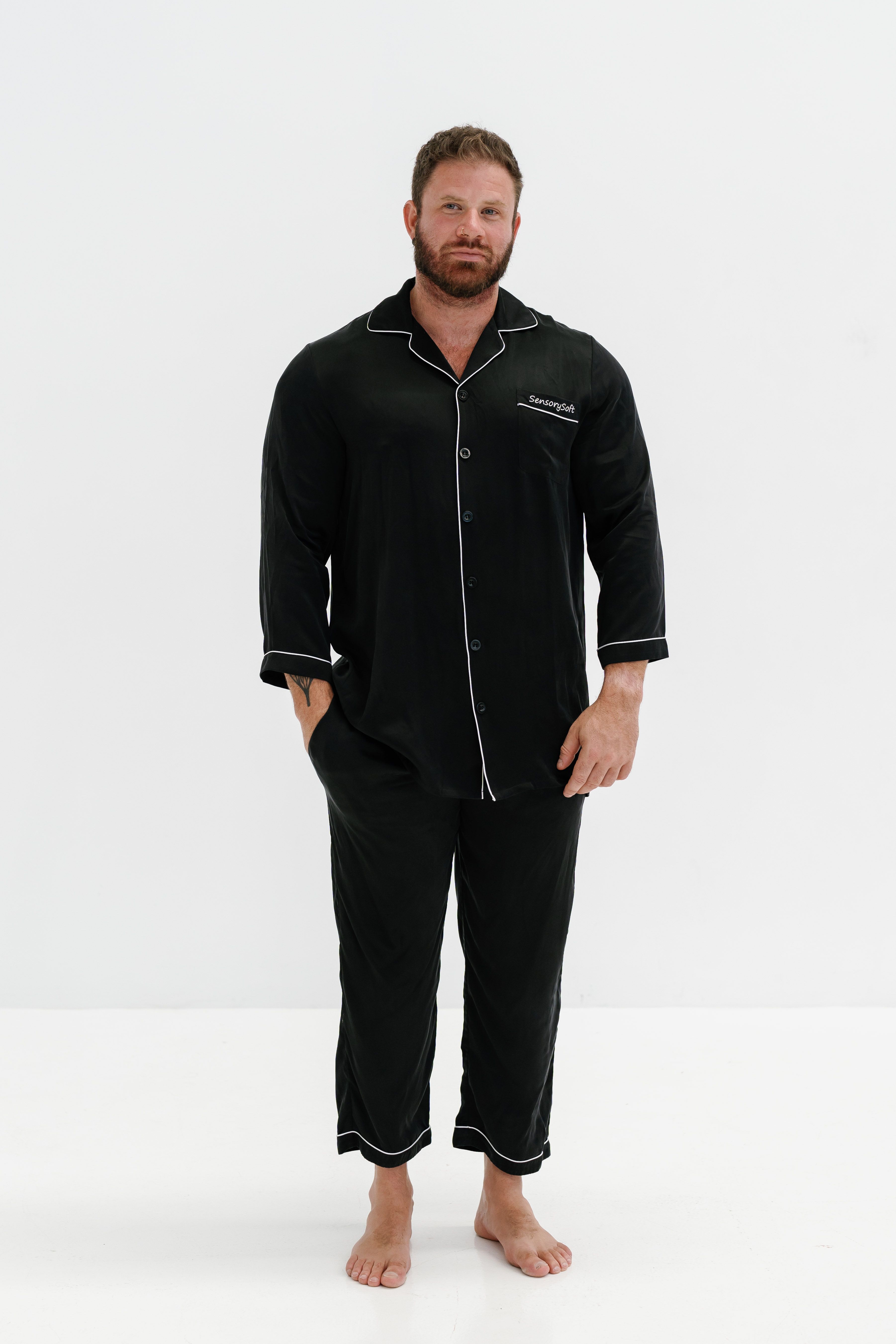 A man in black pajamas standing in front of a white background · Free ...