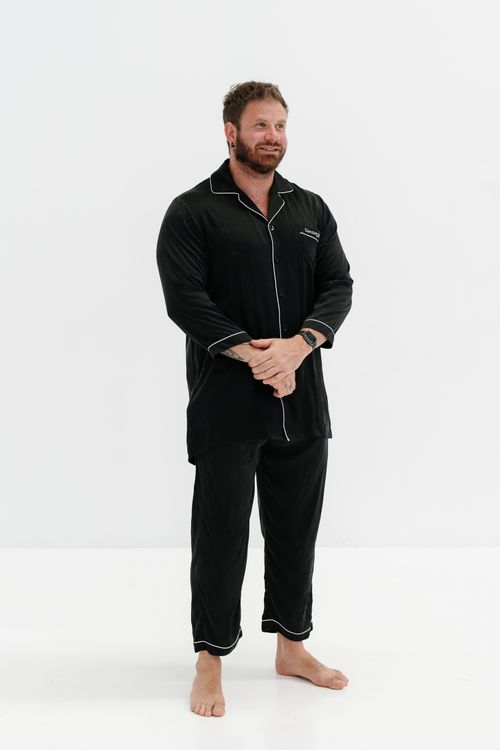 Free Stylish men's pajama set in black with contrast piping, perfect for comfortable nights. Stock Photo