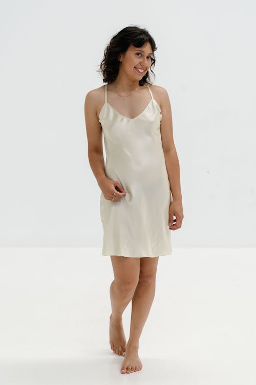 A woman in a white silk slip dress