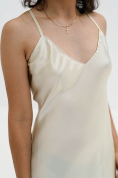 Close-up of a person wearing an elegant silk dress and a delicate necklace.