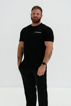 Man in black casual wear posing confidently in studio setting.