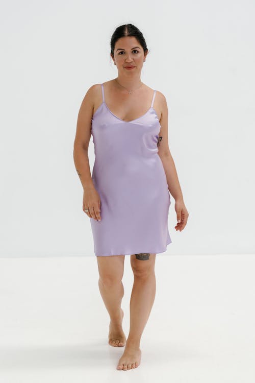 A woman in a purple satin slip dress