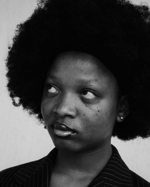 Free Expressive black and white portrait of a woman with afro hair looking upwards. Stock Photo