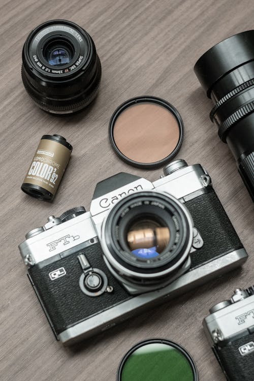 A camera, lens, and other accessories are laid out on a table