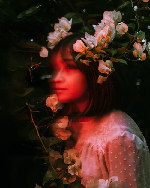 Beautiful Woman in Dress Posing by White Flowers in Garden