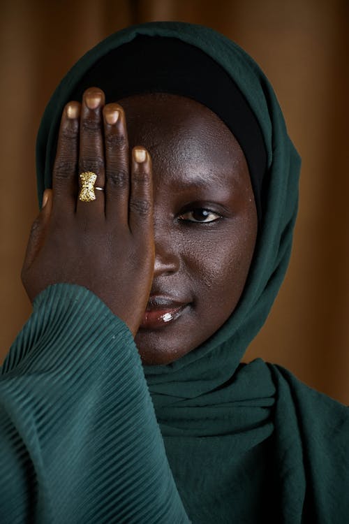 A woman in a green hijab covering her face