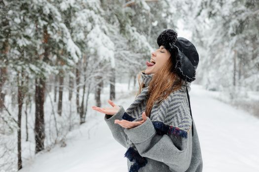 A Beautiful Playful Woman with Her Mouth Open Tasting Snow