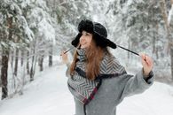 A Playful Woman Pulling the Strings of Her Trapper Hat