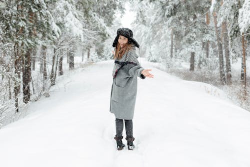 站在雪地上的灰色外套的女人