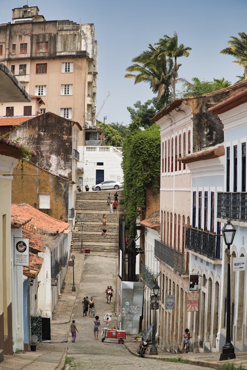 A narrow street with people walking down it