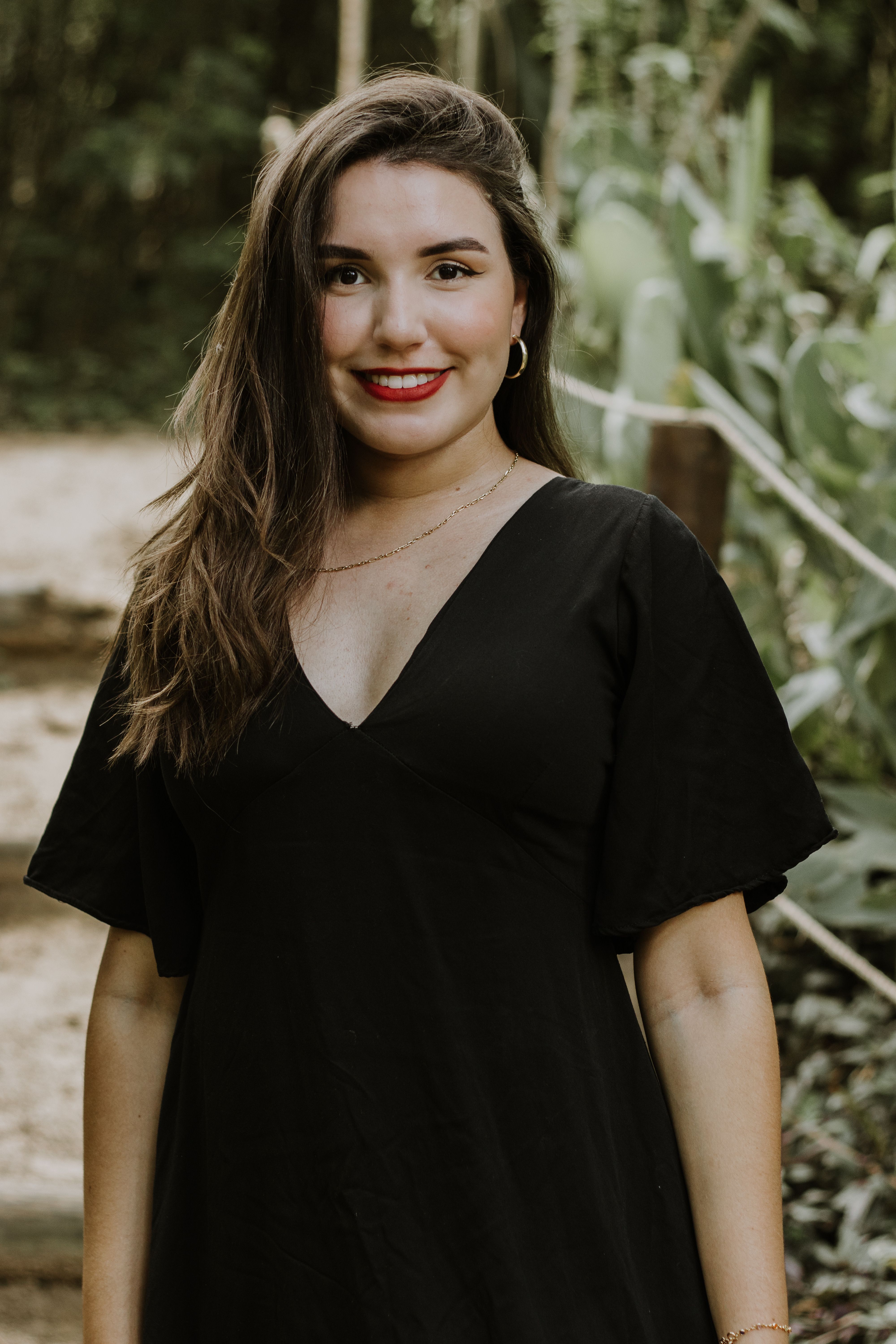 A woman in a black dress smiling · Free Stock Photo
