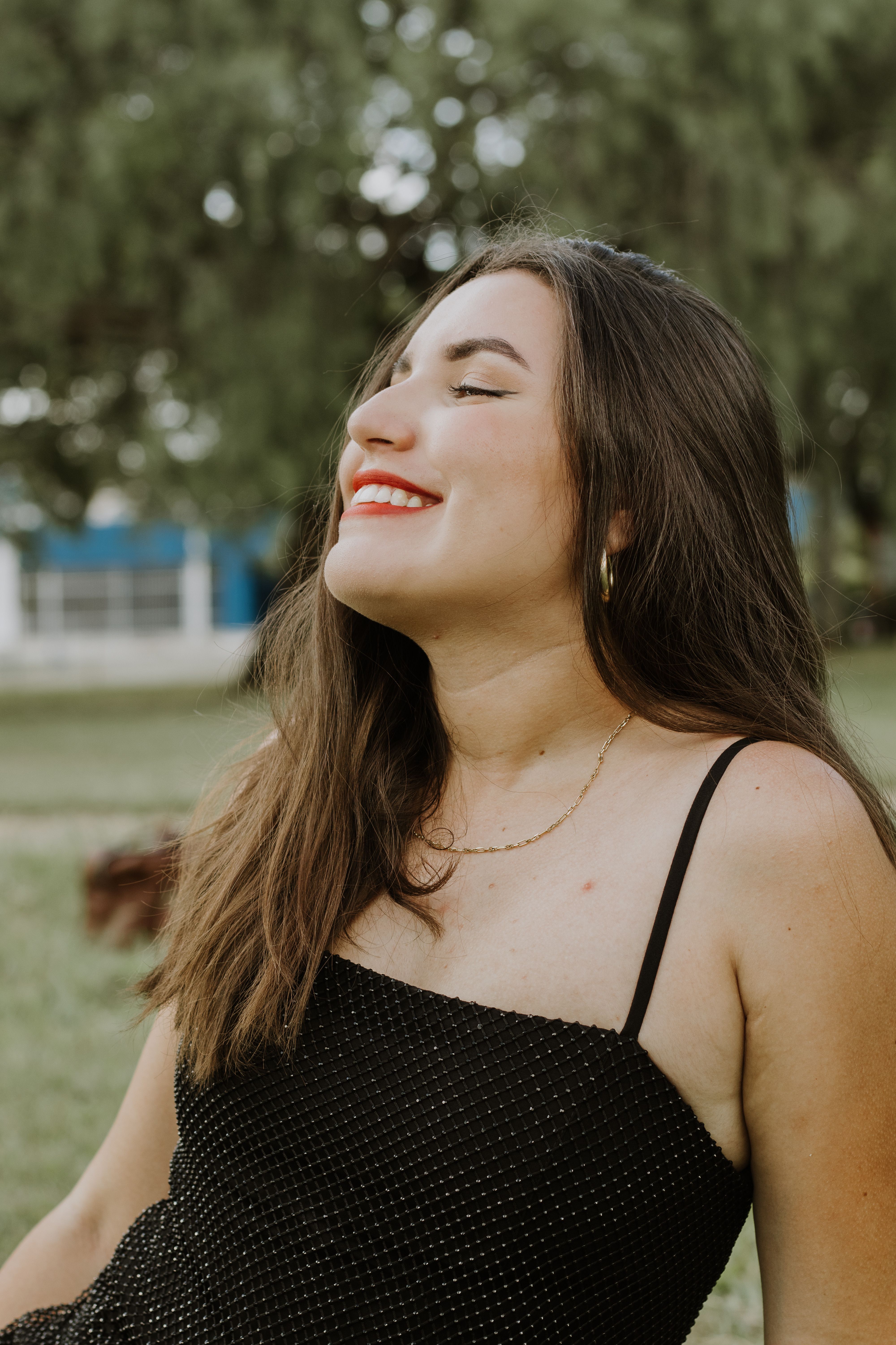 Cute Brunette Woman in Black Dress Smiling in Park · Free Stock Photo