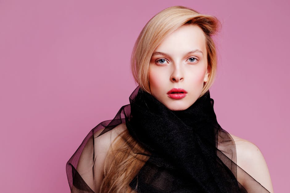 Arjen vinkit ja kotimuotoilu Arjen vinkit ja kotimuotoilu - Striking portrait of a woman with blonde hair and red lips against a pink background.