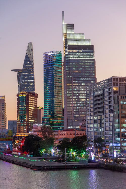 A city skyline with tall buildings and water