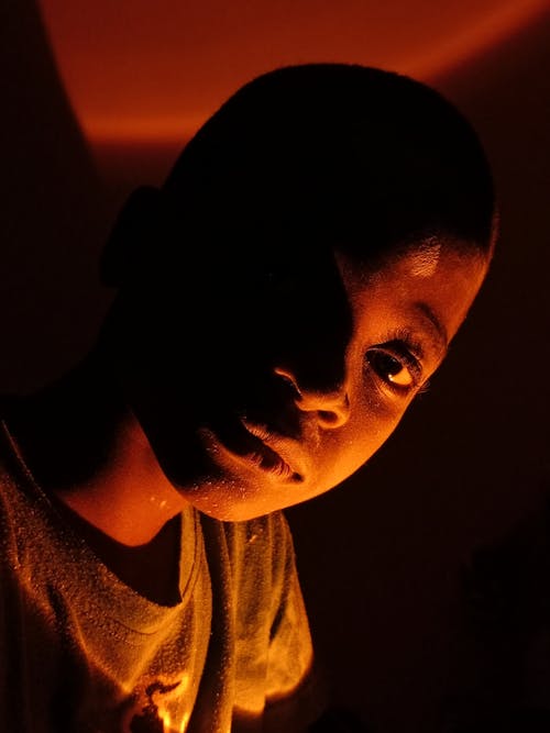 A young boy with his face in the dark