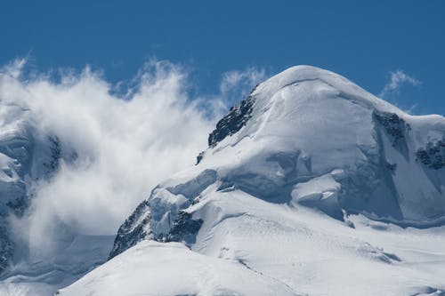 A person is standing on top of a snowy mountain